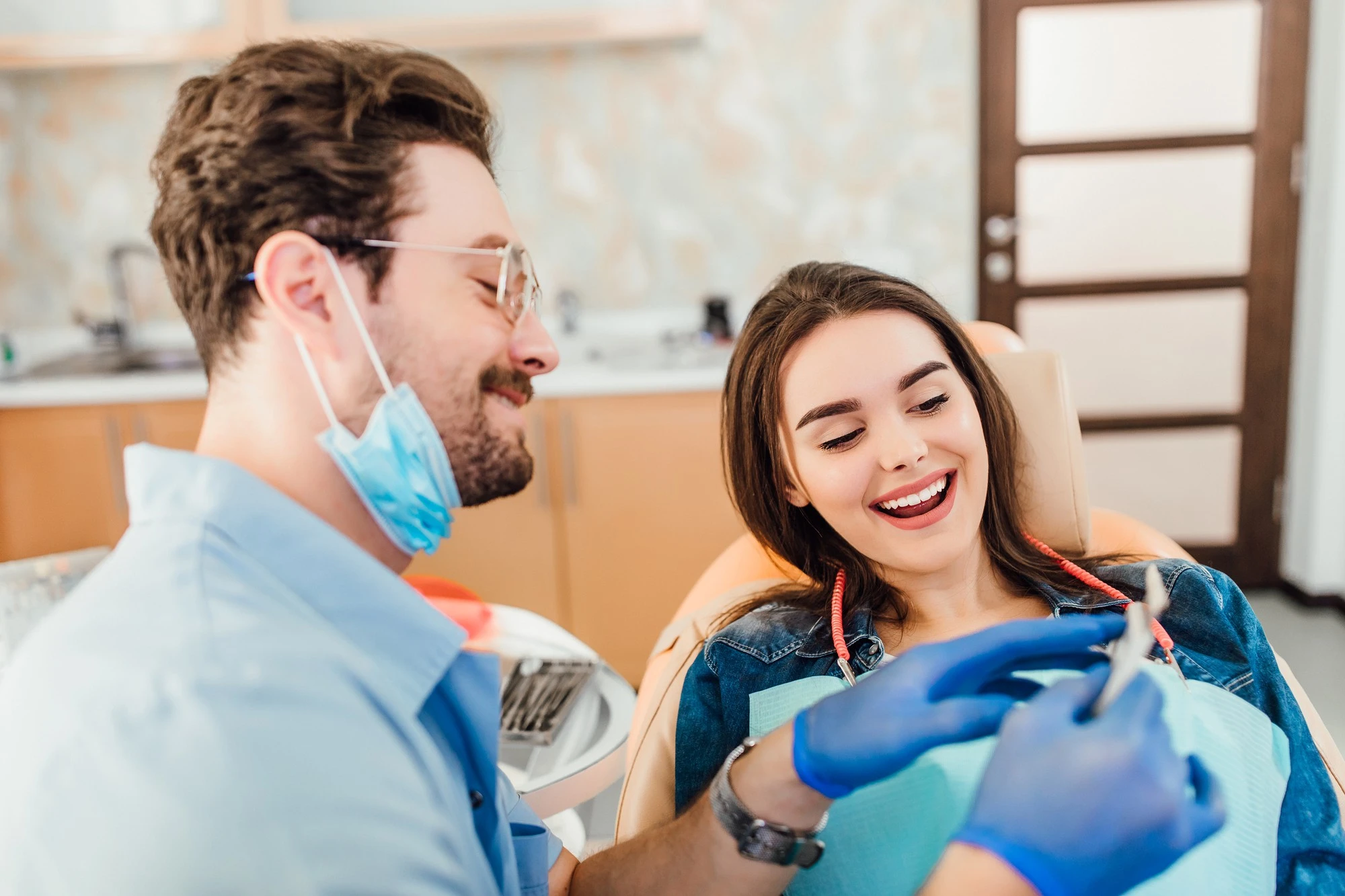Dentiste comparant la teinte des dents avec un nuancier de blanchiment.