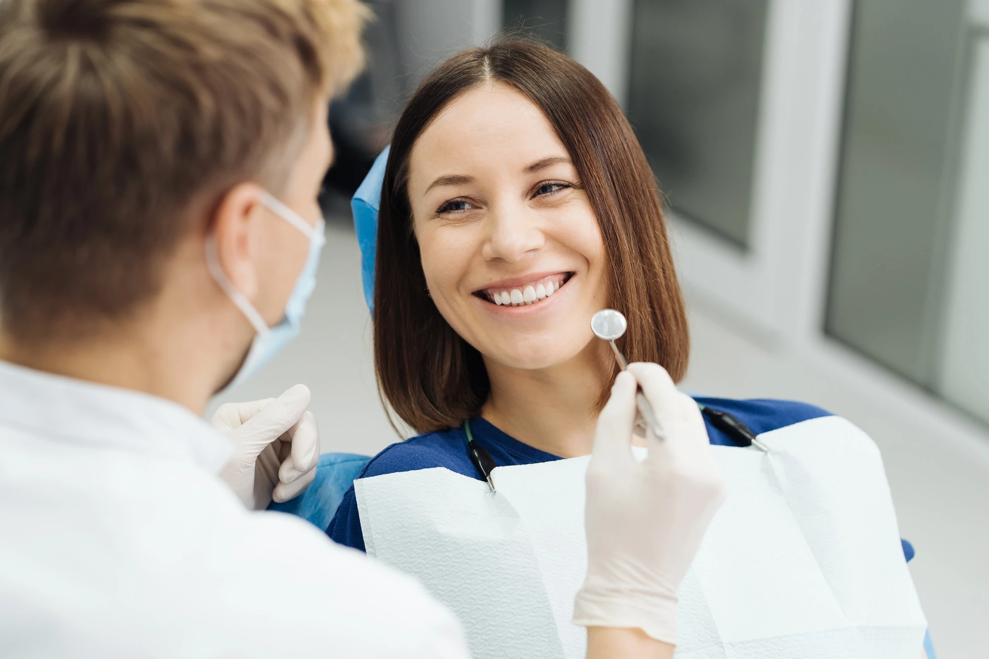Dentiste expliquant un traitement dentaire à un patient.